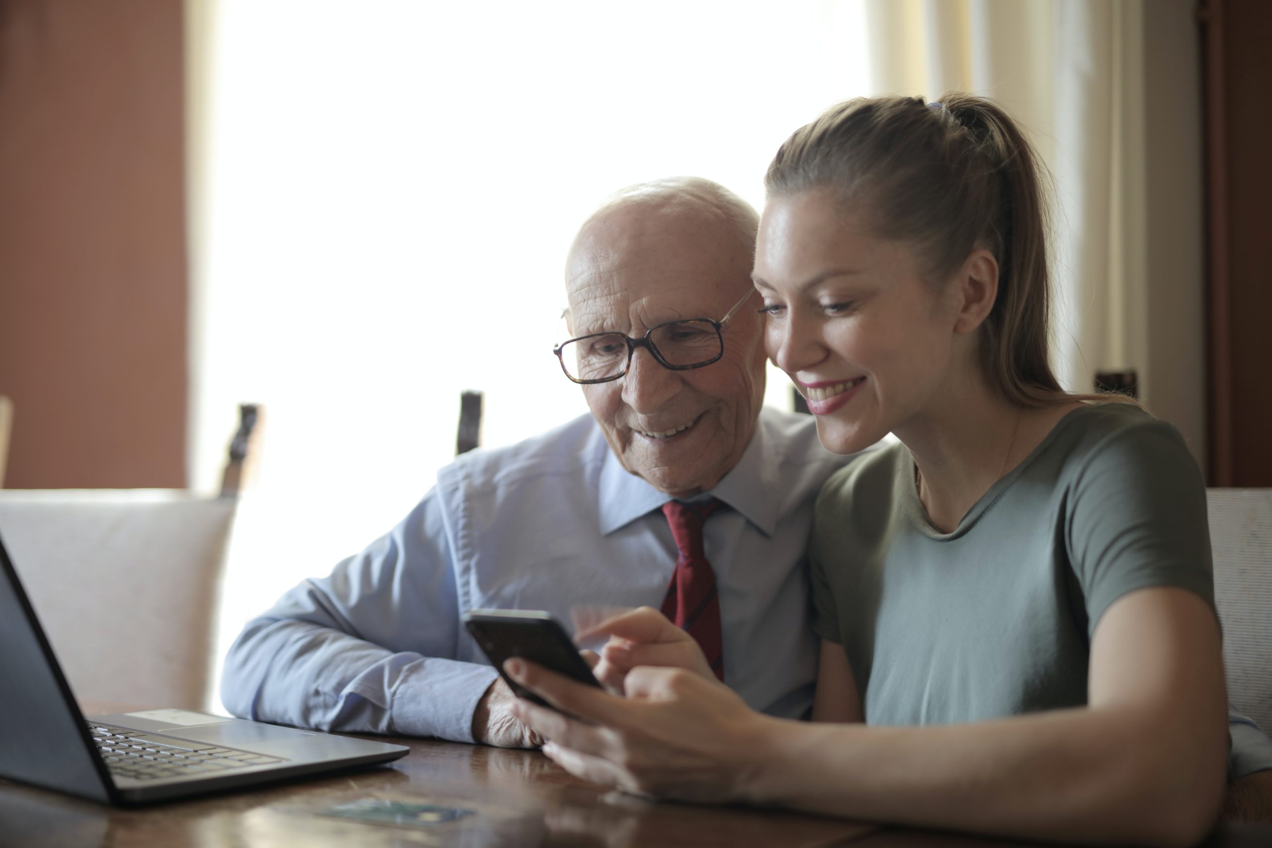 Older man and younger woman looking at phone
